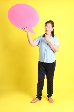 Sarı arka planda açık mavi gömlek giyen Asyalı son sınıf öğrencisi..