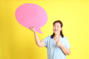 Sarı arka planda açık mavi gömlek giyen Asyalı son sınıf öğrencisi..