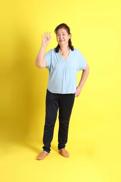 Asian Senior Woman Wearing Light Blue Shirt Standing Yellow Background — 스톡 사진