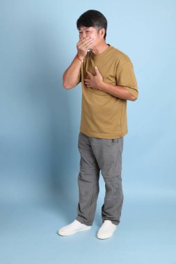 Mavi arka planda sıradan giyinmiş kıdemli Asyalı adam..