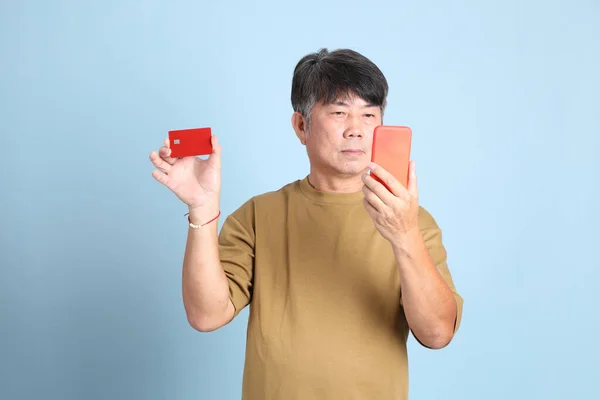 Der Ältere Asiatische Mann Mit Lässiger Kleidung Steht Auf Blauem — Stockfoto