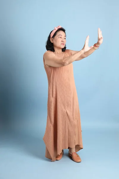 Mulher Asiática Sênior Com Marrom Vestido Sobre Fundo Azul — Fotografia de Stock