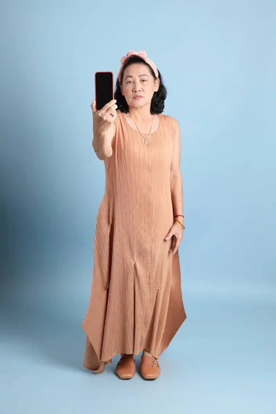 青い背景に身を包んだ茶色のアジア系の先輩女性 — ストック写真
