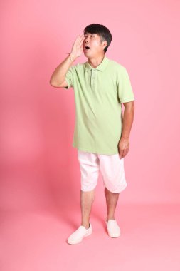 Pembe arka planda sıradan giyinmiş kıdemli Asyalı adam..