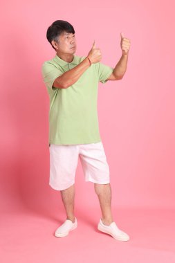 Pembe arka planda sıradan giyinmiş kıdemli Asyalı adam..