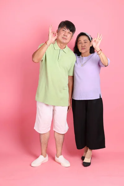 Pembe Arka Planda Sıradan Kıyafetler Giyen Son Sınıf Asyalı Çift — Stok fotoğraf