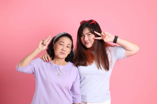 穿着休闲装站在粉色背景上的亚洲家庭 — 图库照片