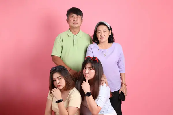 Pembe Arka Planda Sıradan Giyinmiş Asyalı Aile — Stok fotoğraf