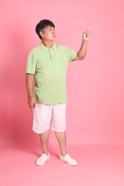 Pembe arka planda sıradan giyinmiş kıdemli Asyalı adam..