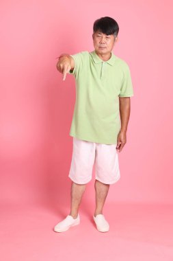 Pembe arka planda sıradan giyinmiş kıdemli Asyalı adam..