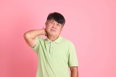 Pembe arka planda sıradan giyinmiş kıdemli Asyalı adam..