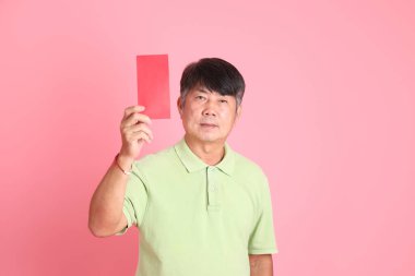 Pembe arka planda sıradan giyinmiş kıdemli Asyalı adam..