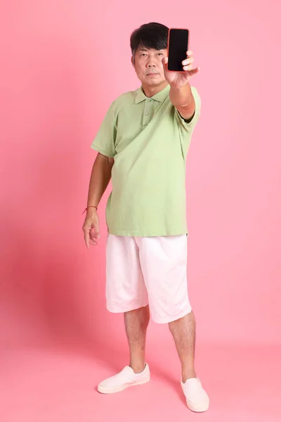 那个穿着休闲装站在粉色背景上的亚裔老人 — 图库照片