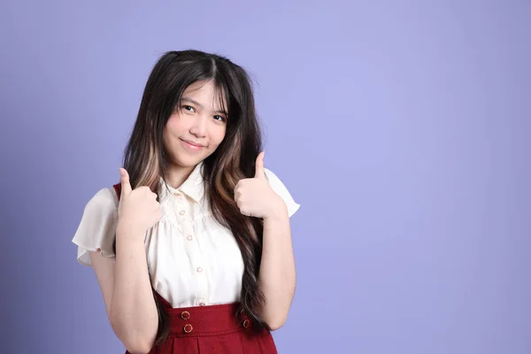 Mor Arka Planda Duran Kolej Kıyafetli Tatlı Asyalı Genç Kadın — Stok fotoğraf