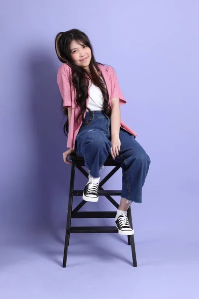 Linda Chica Asiática Joven Con Ropa Casual Sentado Fondo Púrpura —  Fotos de Stock