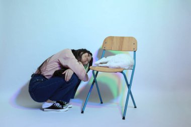 Stüdyoda jel rengi yıldırımın altında poz veren sıradan giyinmiş genç Asyalı kız..