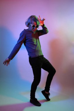 Havalı kıdemli Asyalı adam beyaz arka planda, renk jölesinin altında duruyor.. 