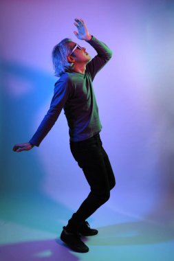 Havalı kıdemli Asyalı adam beyaz arka planda, renk jölesinin altında duruyor.. 