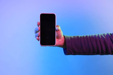 Asyalı adam canlı rengin altında akıllı telefonu tutuyor..
