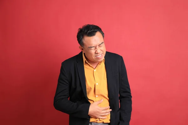 Aziatische Man Van Middelbare Leeftijd Die Rode Achtergrond Staat — Stockfoto