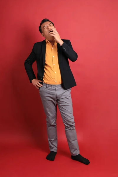 赤い背景に立つアジア系の中年男性 — ストック写真