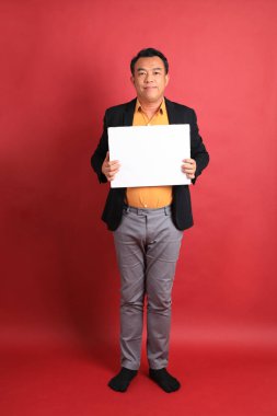 Kırmızı arka planda duran Asyalı orta yaşlı adam..