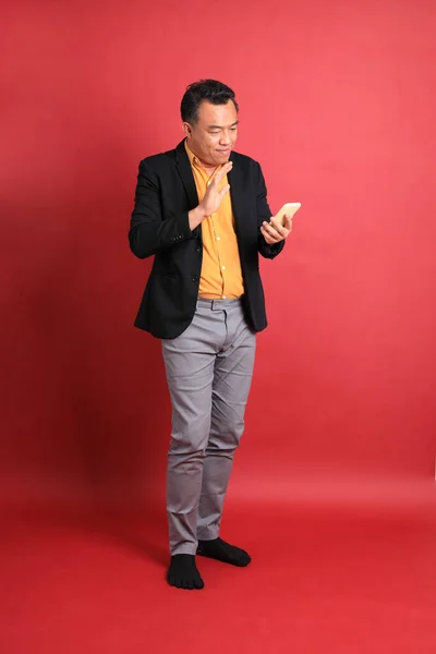 Der Asiatische Mann Mittleren Alters Steht Auf Dem Roten Hintergrund — Stockfoto