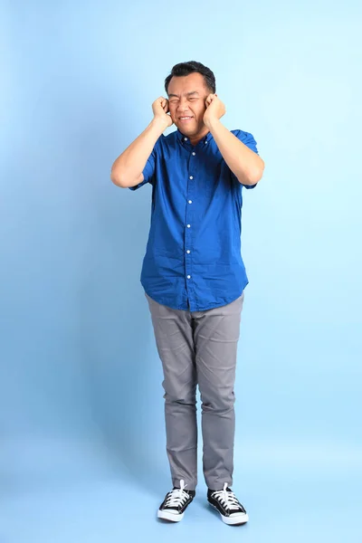青の背景に青いシャツを着たアジア系の中年男性 — ストック写真
