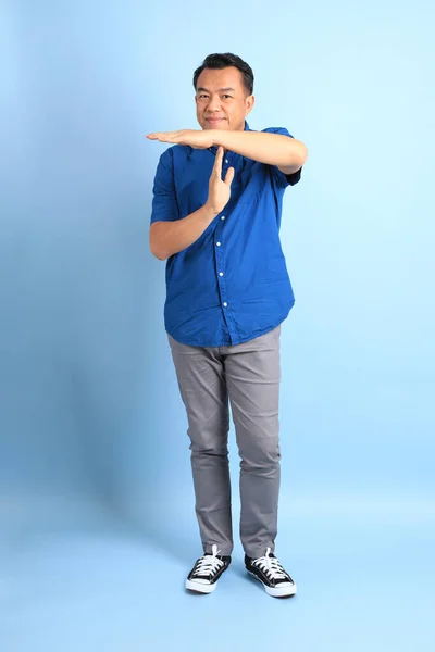 Азиатский Мужчина Средних Лет Голубой Рубашке Стоит Синем Фоне — стоковое фото