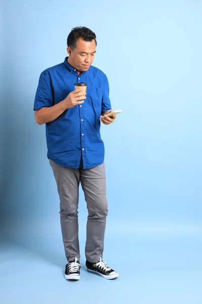 Азиатский Мужчина Средних Лет Голубой Рубашке Стоит Синем Фоне — стоковое фото