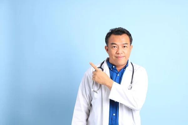 Ανώτερος Γιατρός Της Ασίας Στέκεται Στο Μπλε Φόντο — Φωτογραφία Αρχείου