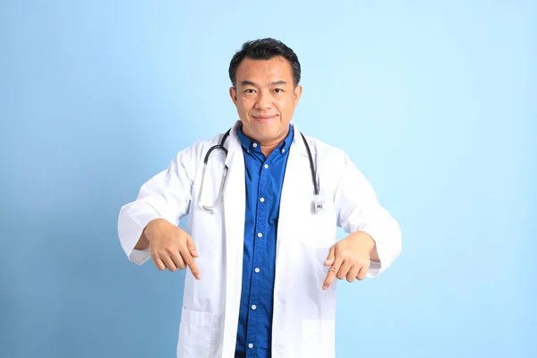 The senior Asian physician standing on the blue background.