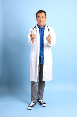 Mavi arka planda duran kıdemli Asyalı doktor..