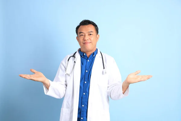 站在蓝色背景上的资深亚洲医生 — 图库照片