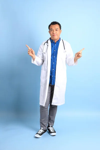 Kék Háttéren Álló Vezető Ázsiai Orvos — Stock Fotó