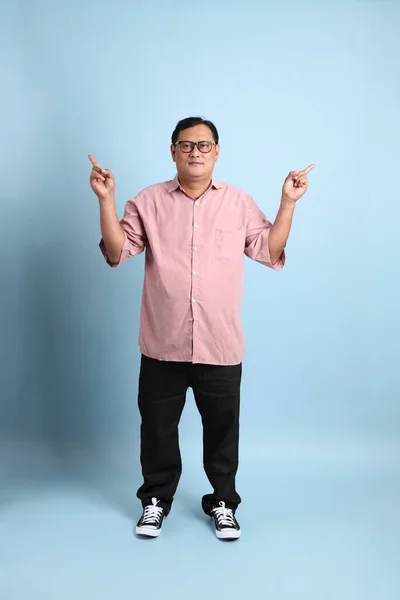 Adult Asian Man Pink Shirt Standing Blue Background – stockfoto