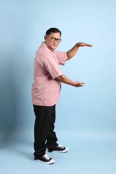 Adult Asian Man Pink Shirt Standing Blue Background – stockfoto