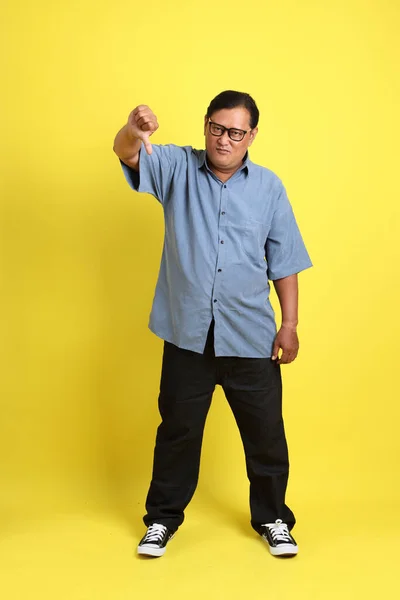 Adult Asian Man Blue Shirt Standing Yellow Background – stockfoto