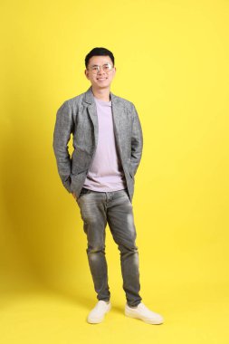 Sarı arka planda gri ceketli Asyalı LGBTQ adamı..