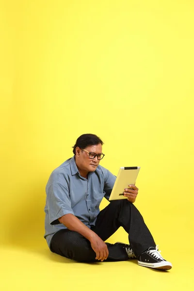 Adult Asian Man Blue Shirt Sitting Yellow Background — Stockfoto