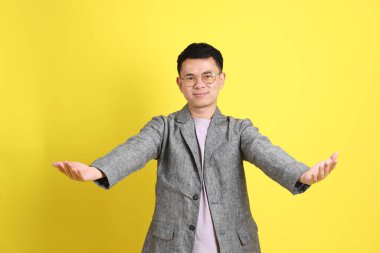 Sarı arka planda gri ceketli Asyalı LGBTQ adamı..