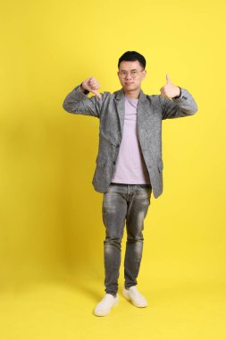 Sarı arka planda gri ceketli Asyalı LGBTQ adamı..