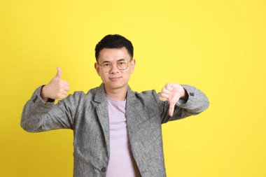 Sarı arka planda gri ceketli Asyalı LGBTQ adamı..