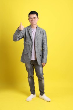 Sarı arka planda gri ceketli Asyalı LGBTQ adamı..