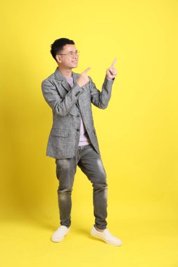 Sarı arka planda gri ceketli Asyalı LGBTQ adamı..