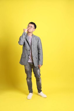 Sarı arka planda gri ceketli Asyalı LGBTQ adamı..