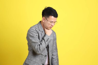 Sarı arka planda gri ceketli Asyalı LGBTQ adamı..