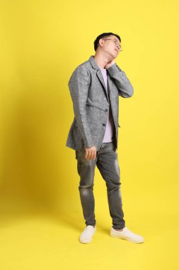 Sarı arka planda gri ceketli Asyalı LGBTQ adamı..