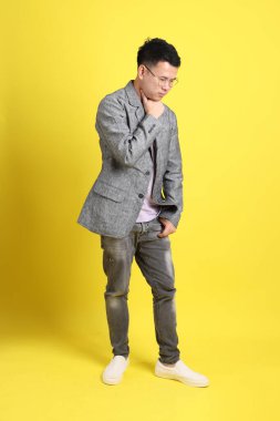 Sarı arka planda gri ceketli Asyalı LGBTQ adamı..