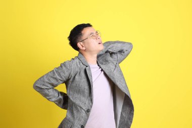 Sarı arka planda gri ceketli Asyalı LGBTQ adamı..